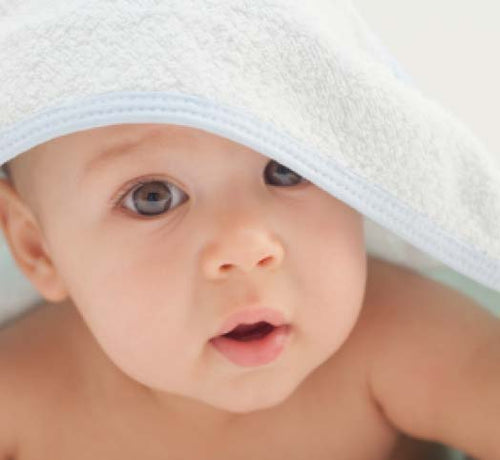 Bebé tapado con una toalla después de recibir un baño de burbujas con productos de higiene Mustela - Mustela España - 1