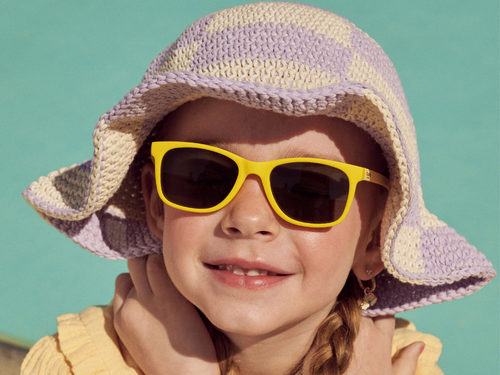 Una niña entre 3 y 5 años disfrutando del verano con los ojos protegidos del sol, lleva gafas de sol Girasol de color amarillo de Mustela by Parafina. slider - Mustela España - 2