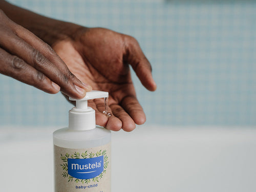 Padre aplica un poco de Gel 2 en 1 familiar para cabello y cuerpo en sus manos. - Mustela España - 3