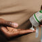Padre aplicándose crema hidratante bio Mustela en la mano, ideal para toda la familia.