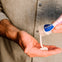 Un papá se dosifica en la mano la crema bálsamo 123 de Mustela para picores y rojeces antes de aplicarlo en la zona del pañal de su bebé