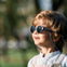 Bebé entre 1 y 2 años disfruta de un día soleado en el parque con las gafas de sol aguacate de Mustela by Parafina en color azul. slider