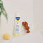 Bote de gel hidratante para bebés con piel seca en una repisa del baño familiar junto una esponja
