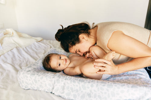 Madre haciendo cosquillas a su bebé sobre el cambiador. - Mustela España - 1