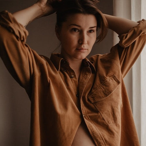 Una mujer embarazada de pocos meses se hace una coleta con el cabello - Mustela España - 1