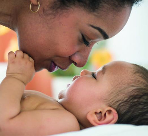 Una mamá da besos y mimos a su bebé recién bañado con productos para la higiene corporal Mustela - Mustela España - 1