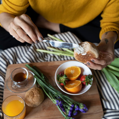 Mujer disfrutando de un desayuno nutritivo y delicioso de fruta, café y pan con mantequilla - Mustela España - 1