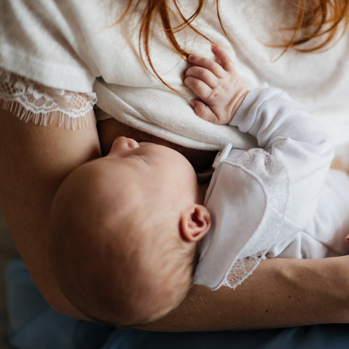 Un bebé se queda dormido plácidamente en los brazos de su madre mientras mama. - Mustela España - 1