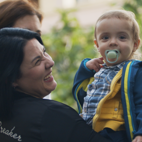 Mamá sonriendo mientras coge en brazos a su hijo - Mustela España - 1