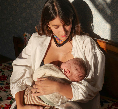 Madre amamantando a su bebe sentada sobre una cama - Mustela España - 1