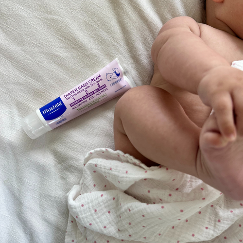Hora del cambio del pañal del bebé con el bebé recostado y la crema bálsamo 1 2 3 de Mustela. - Mustela España - 1