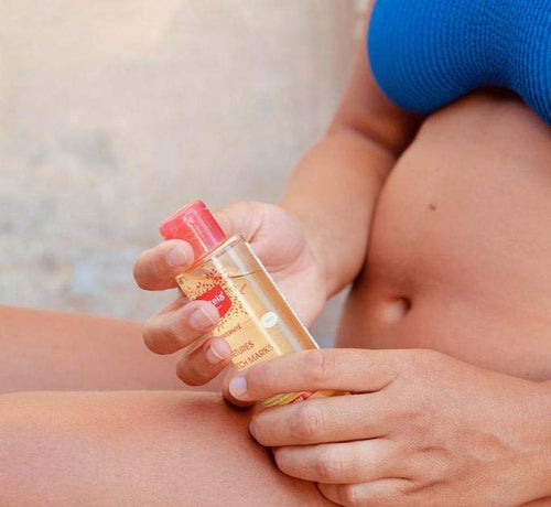 Mujer embarazada y en ropa interior aplicándose aceite para las estrías - Mustela España - 1