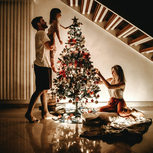 Padres con su hija pequeña decorando el árbol de navidad - Mustela España - 1