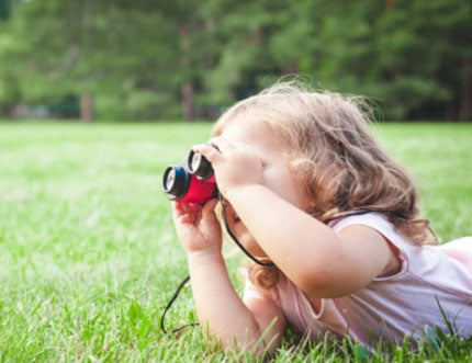 Niña disfrutando en la naturaleza usando unos prismáticos - Mustela España - 1