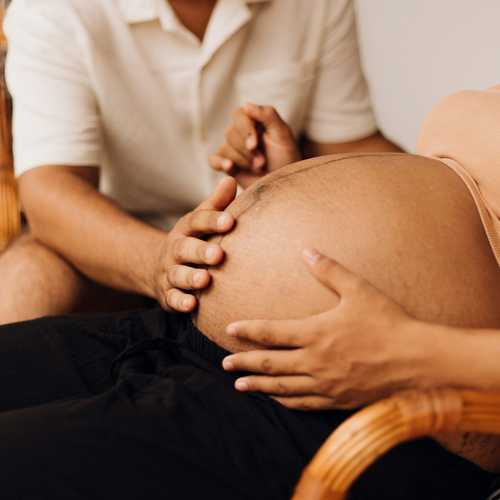 Un papá tocando la tripa embarazada de su pareja para sentir los movimientos de su bebé. - Mustela España - 1