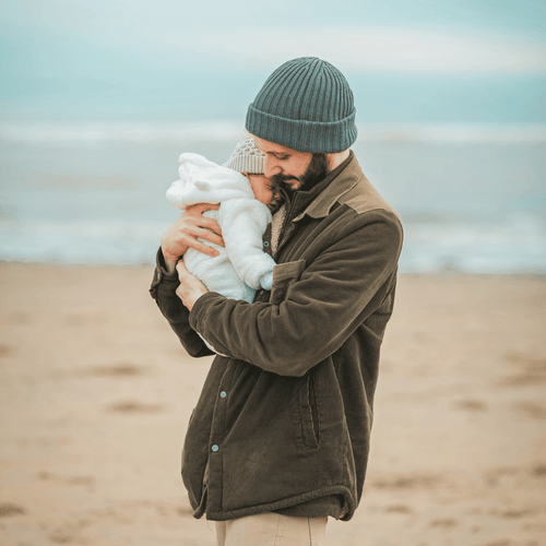 Un padre abrazando a su bebé en la playa - Mustela España - 1