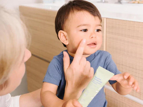 Una madre aplica el bálsamo universal de Mustela en el rostro del bebé  - Mustela España - 1