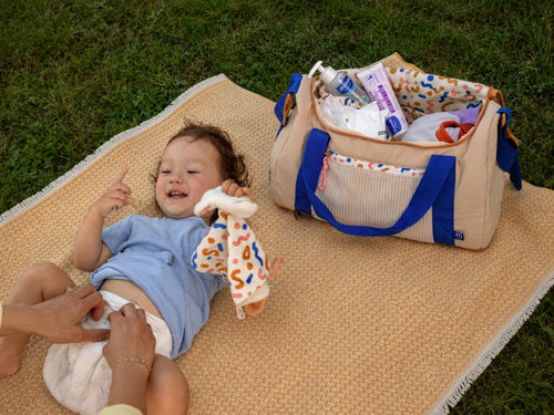 mamá cambiando el pañal en una toalla frente a la bolsa - Mustela España - 3