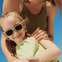 Una niña con su mamá con gafas de sol Girasol verde, entre 3 y 5 años.