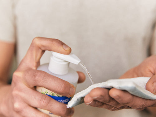 Padre aplica un poco de agua micelar Mustela en una toallita como desmaquillante - Mustela España - 3