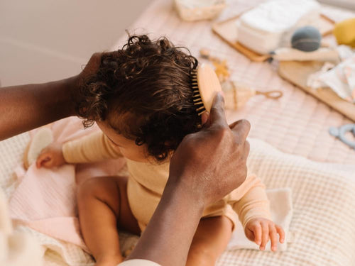 Un padre está peinando el cabello rizado de su niña después de aplicar el agua para peinar de Mustela - Mustela España - 5