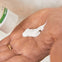 Padre aplica en la palma de la mano un poco de crema para la dermatitis del pañal, o también llamada pañalitis.