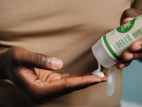 Padre aplicándose crema hidratante bio Mustela en la mano, ideal para toda la familia. - Mustela España - 3