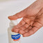 Madre se pone un poco de gel de baño confort en la mano lavar la piel sensible de su bebé.