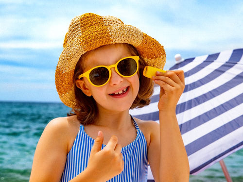Niña disfrutando de un día de playa aplicándose el stick solar de Mustela - Mustela España - 5