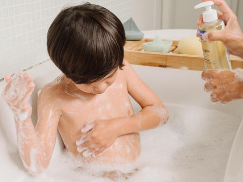 Un niño está tomando su baño con el aceite de ducha Stelatopia Mustela, que hace espuma - Mustela España - 3