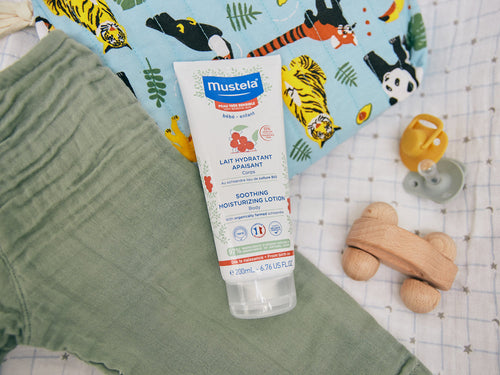 Bote de leche hidratante confort de Mustela junto con la ropa del bebé, pues es ideal para aplicar justo después del baño y aliviar las molestias de las piel sensible.  - Mustela España - 5
