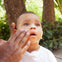 Un padre pone crema solar en la cara de su niño. slider