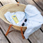 cesta con una toalla, un tubo de crema solar 100ml y unas gafas de sol