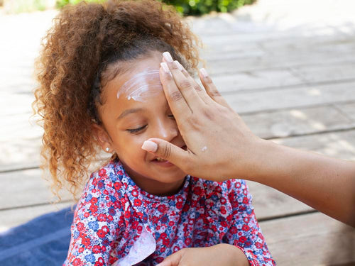 Una madre aplica crema solar en la cara de su niña. slider - Mustela España - 3