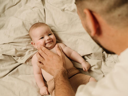 Un padre está aplicando la crema Stelatopia+ antipicor de Mustela en la cara de su bebé con piel atópica - Mustela España - 5