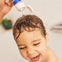 Padre lava el delicado cabello de su bebé con champú Mustela disfrutando de un agradable baño sin que pique en los ojos.