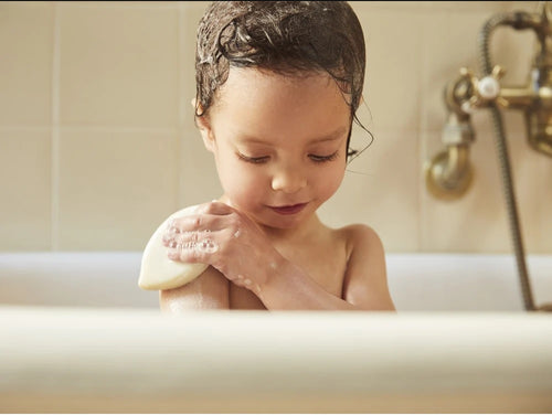 Una niña se ducha con el champú sólido cabello y cuerpo que es fácil de utilizar. - Mustela España - 3