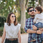 Una familia joven, compuesta por una madre, padre y un bebé, disfruta de un paseo por un parque, llevan gafas Mustela by Parafina en diferentes modelos.slider