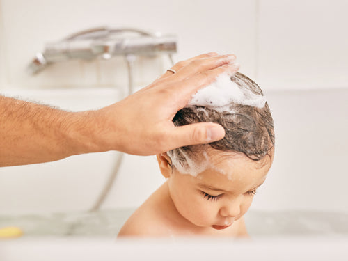 Un padre utiliza el gel de baño y ducha Stelatopia para limpiar el cabello de su niño. - Mustela España - 6