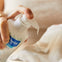 Madre aplica la leche limpiadora de Mustela en una toallita en la cantidad justa gracias a su dosificador